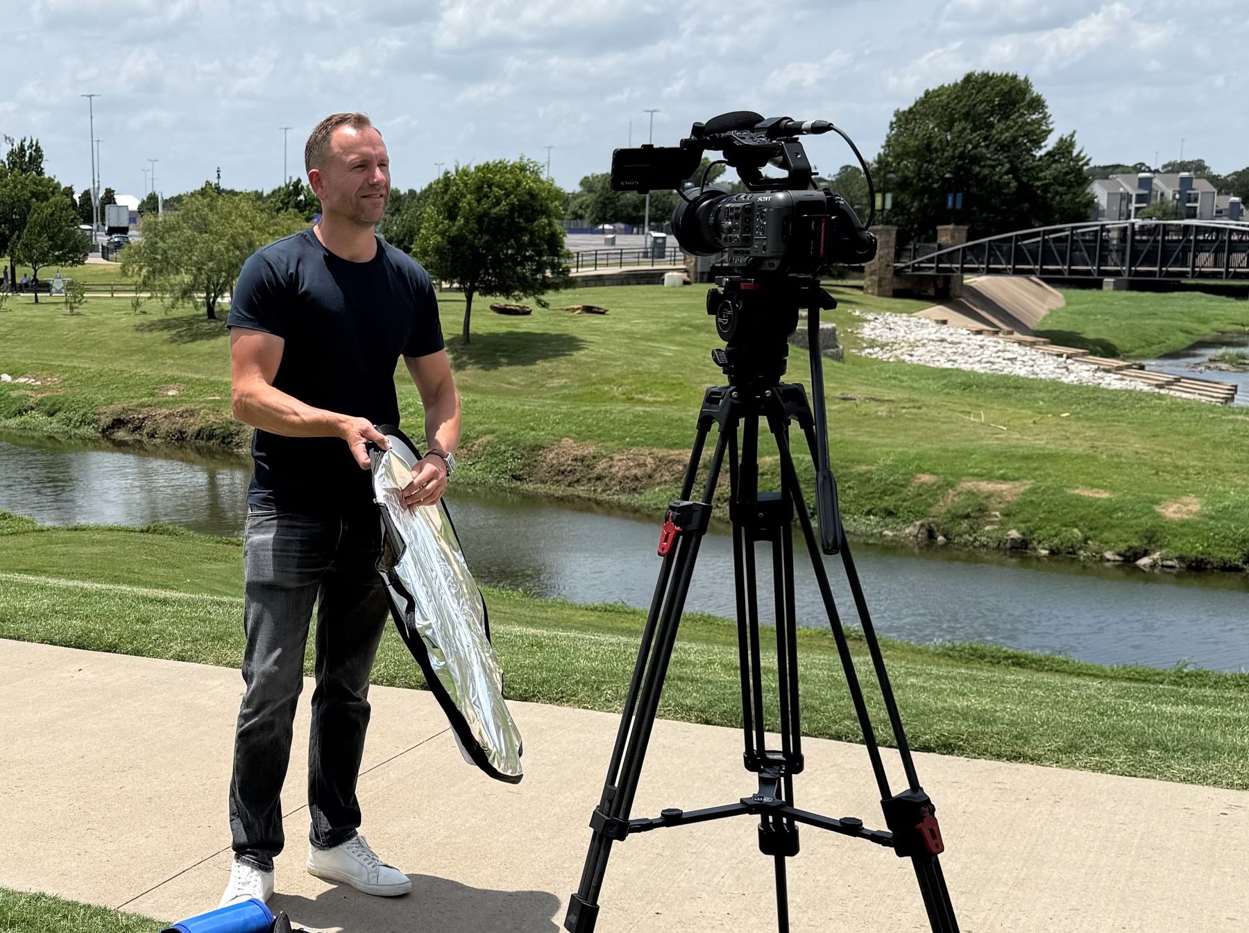 Paul Rhys setting up a Sony FX6 on a tripod by the river in Dallas during the 2026 FIFA World Cup