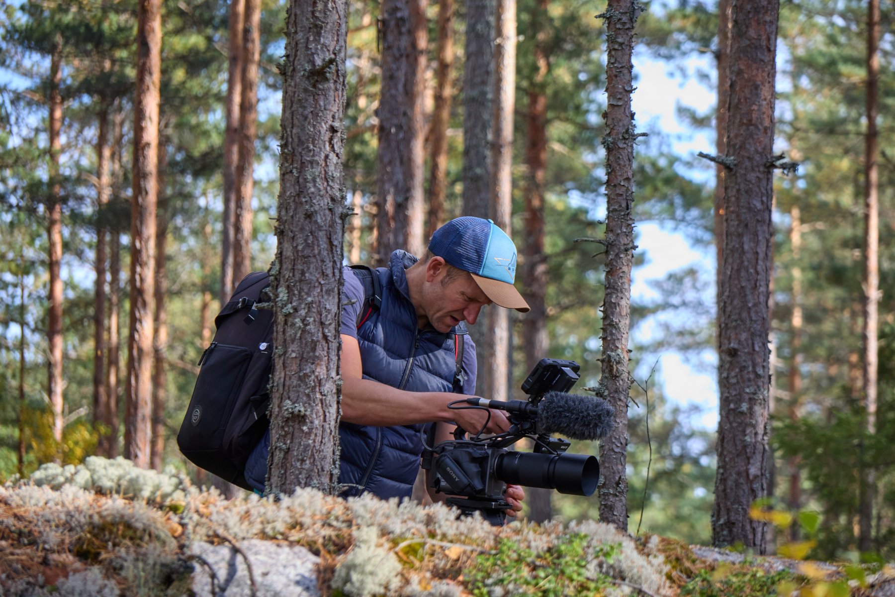 Paul Rhys filming handheld with a Sony FX6 among pine trees in a Swedish forest