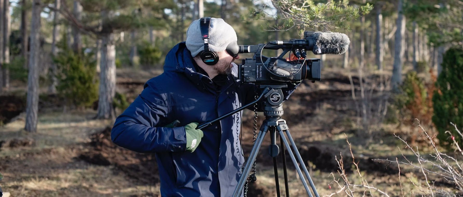 Paul Rhys filming with a camera on a tripod in a Swedish forest