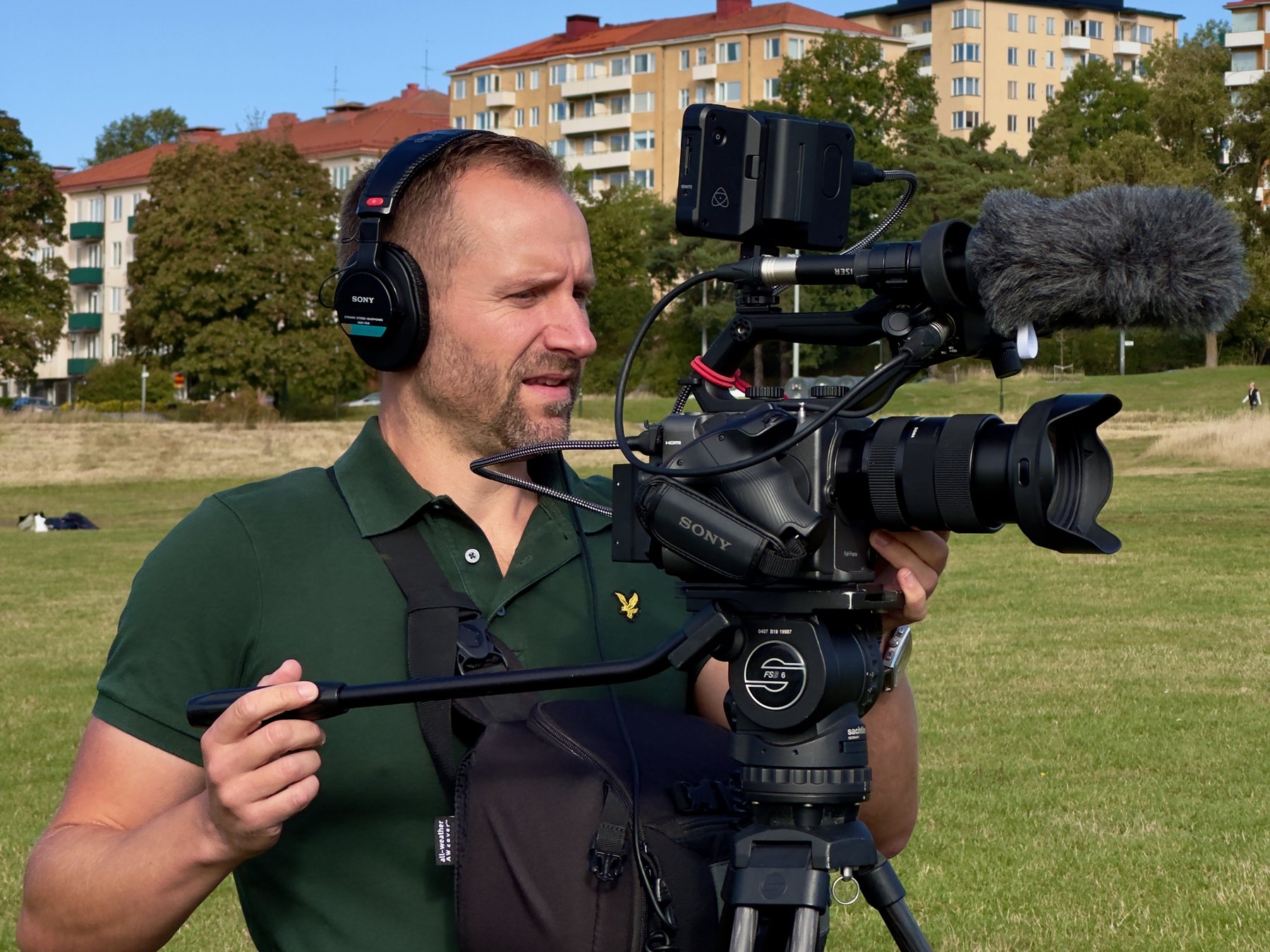 Paul Rhys with a Sony FX6 on a tripod and headphones in a park in Stockholm